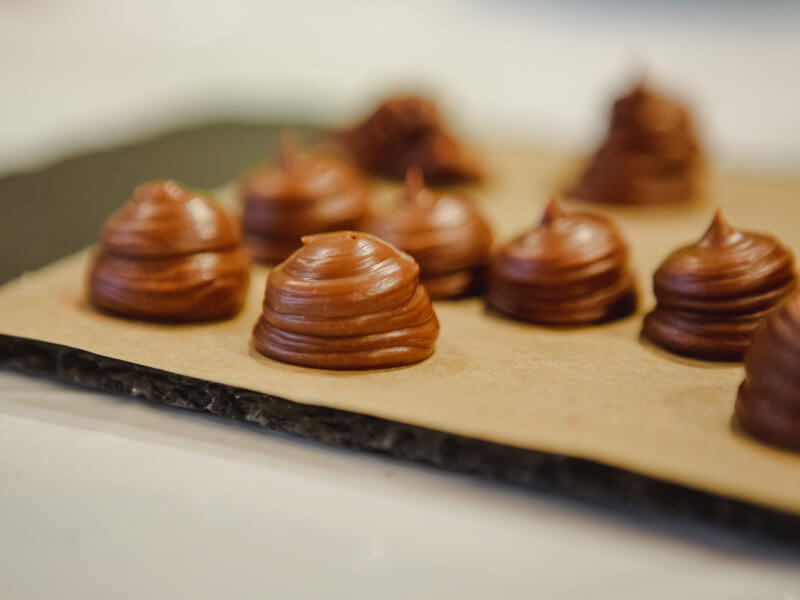 A picture of some handmade chocolates on a wooden board